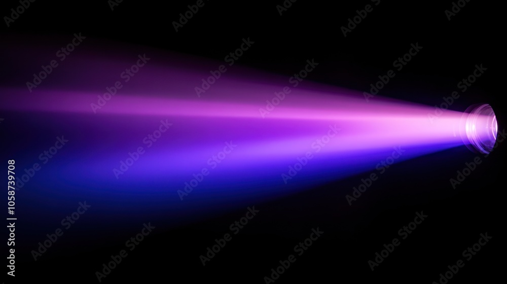 Fototapeta premium A bright, purple and blue light beam shoots out from a small, round source in the bottom right corner of the frame. The beam fades into darkness as it travels to the left side of the image.