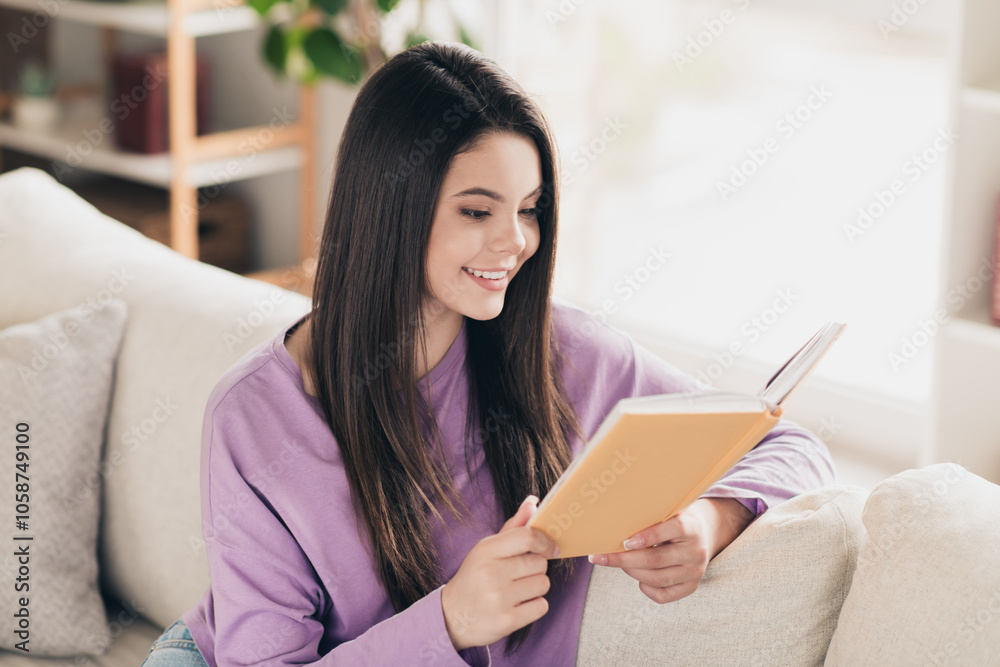 Photo of lovely young teen girl reading book dressed violet garment spacious house bright indoors room Photo of lovely young teen girl reading book dressed violet garment spacious house bright indoors room