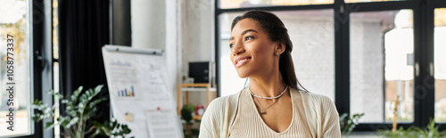 Bright natural light illuminates a young woman as she engages thoughtfully in her work environment.
