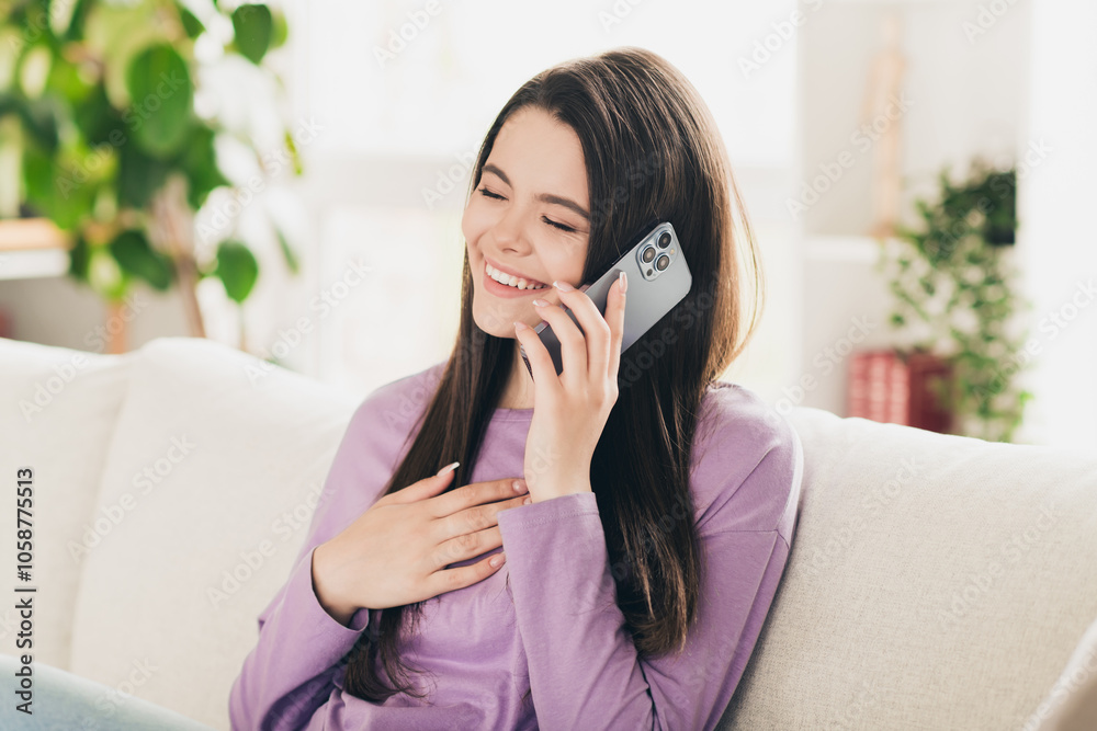 Photo of lovely young teen girl talking phone laughing dressed violet garment spacious house bright indoors room Photo of lovely young teen girl talking phone laughing dressed violet garment spacious house bright indoors room