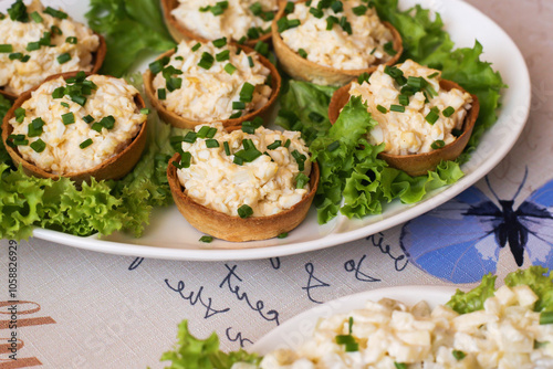 Egg paste cupcake. Egg spread tartlets. Boiles eggs with mayo on baked tarta cake sprinkled with chives onion spring. Salty party snack. Eggs salad on tartlet. photo