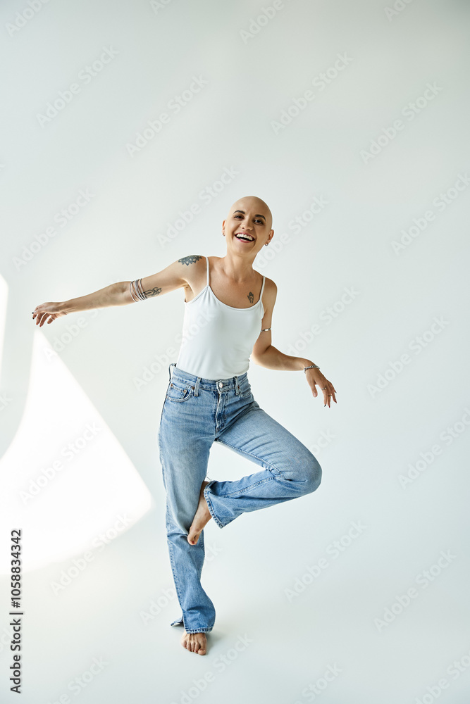 A young bald woman exudes confidence and joy while standing playfully in stylish jeans. A young bald woman exudes confidence and joy while standing playfully in stylish jeans.