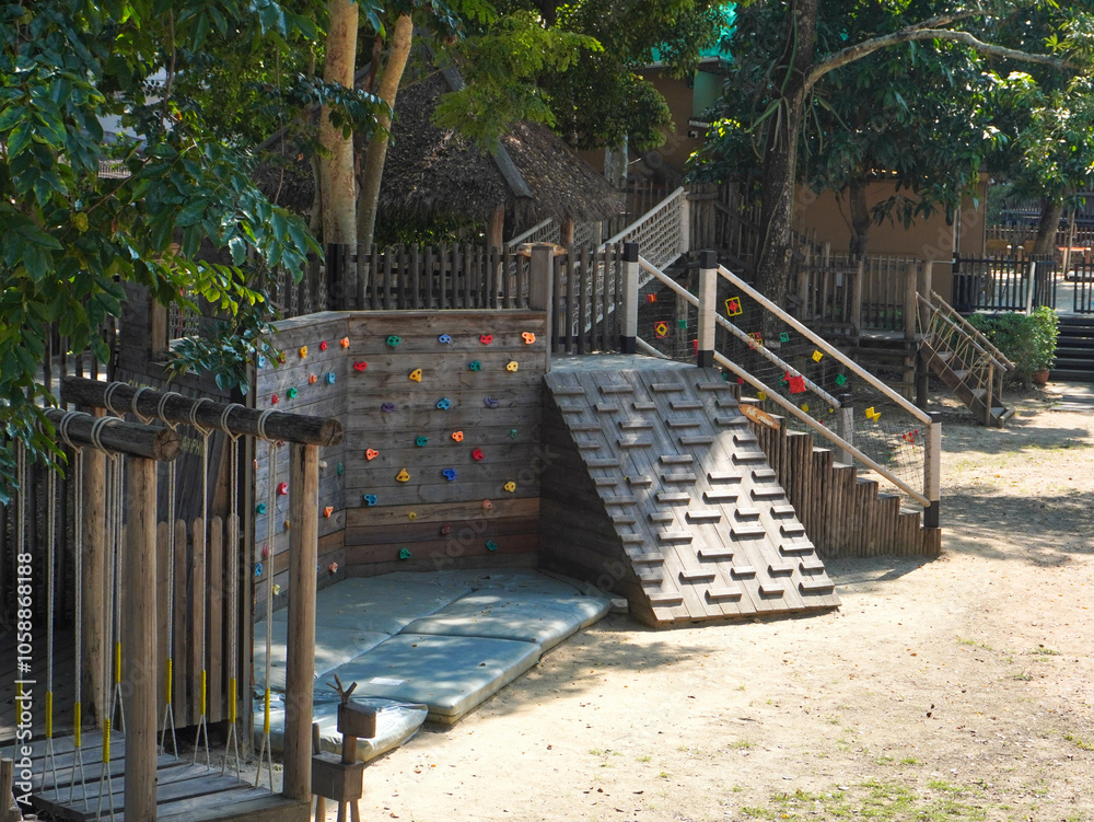 Summer park playground with swings, slides and climbing equipment. Modern wooden playground equipment for children's amusement park. Summer park playground with swings, slides and climbing equipment. Modern wooden playground equipment for children's amusement park.