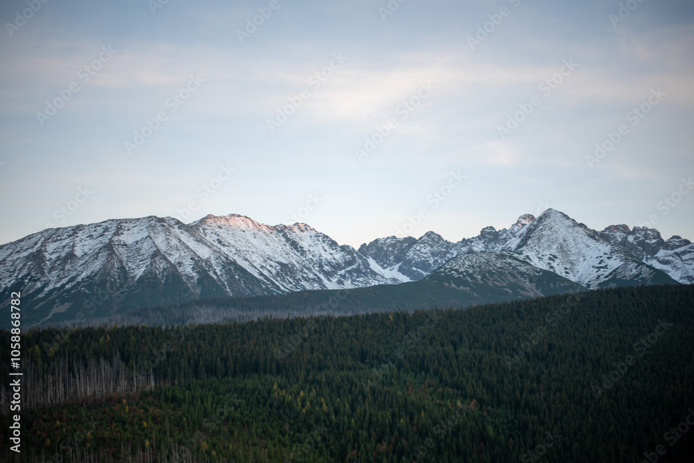 Fototapeta premium The sunset atop Mount Kopieniec in Zakopane, Poland, casts a warm glow over the Tatra Mountains