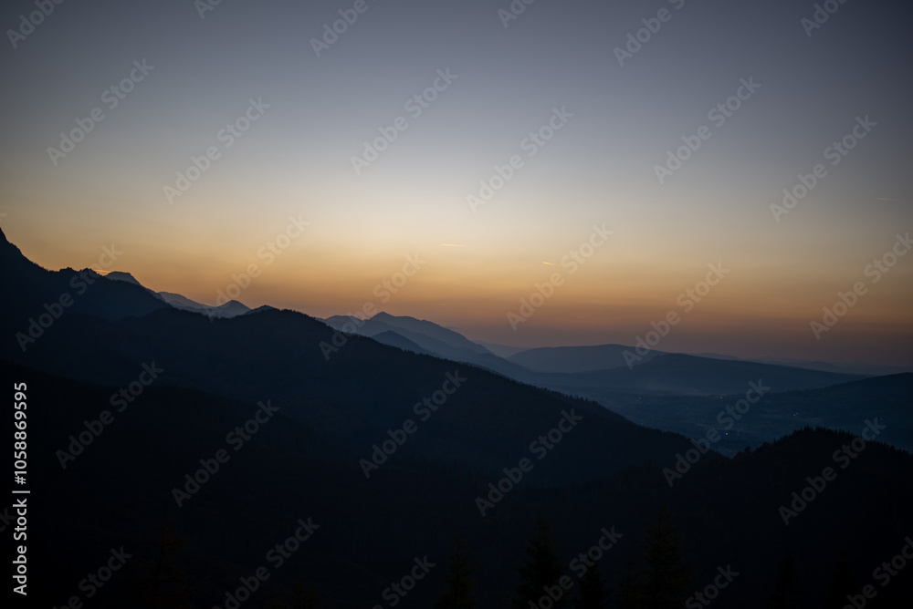 Obraz premium The sunset atop Mount Kopieniec in Zakopane, Poland, casts a warm glow over the Tatra Mountains, creating a stunning landscape