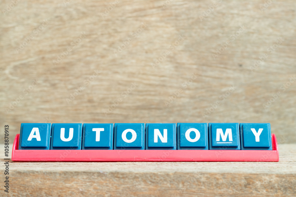 Obraz premium Tile alphabet letter with word autonomy in red color rack on wood background