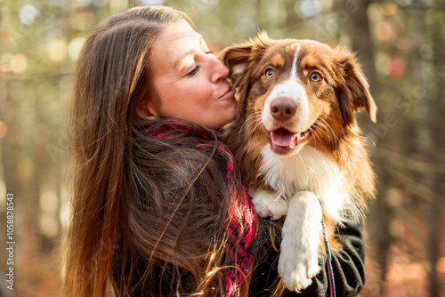 Loving young woman with her shepherd Australian on fall season