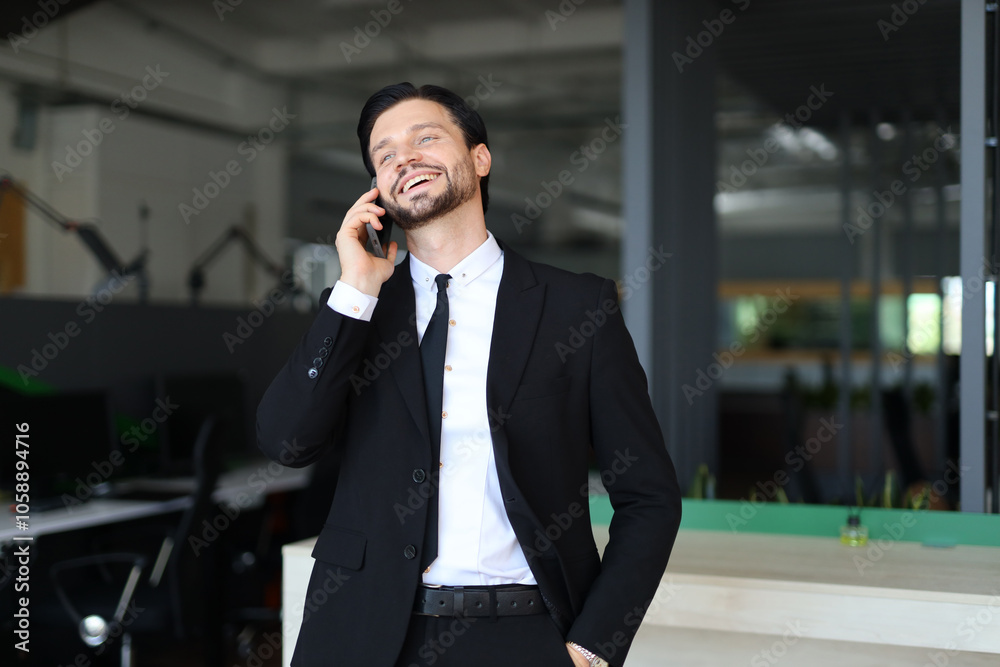 A man in a suit is talking on his cell phone. He is smiling and he is enjoying the conversation A man in a suit is talking on his cell phone. He is smiling and he is enjoying the conversation
