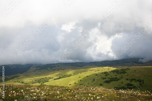 Meadow in the mountains in Crimea before the rain.  Cloud and fog descend on the mountains. Vivid photo of natural landscapes. photo