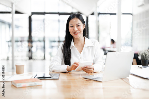 Young attractive businesswoman working on her project with laptop computer in modern office room.