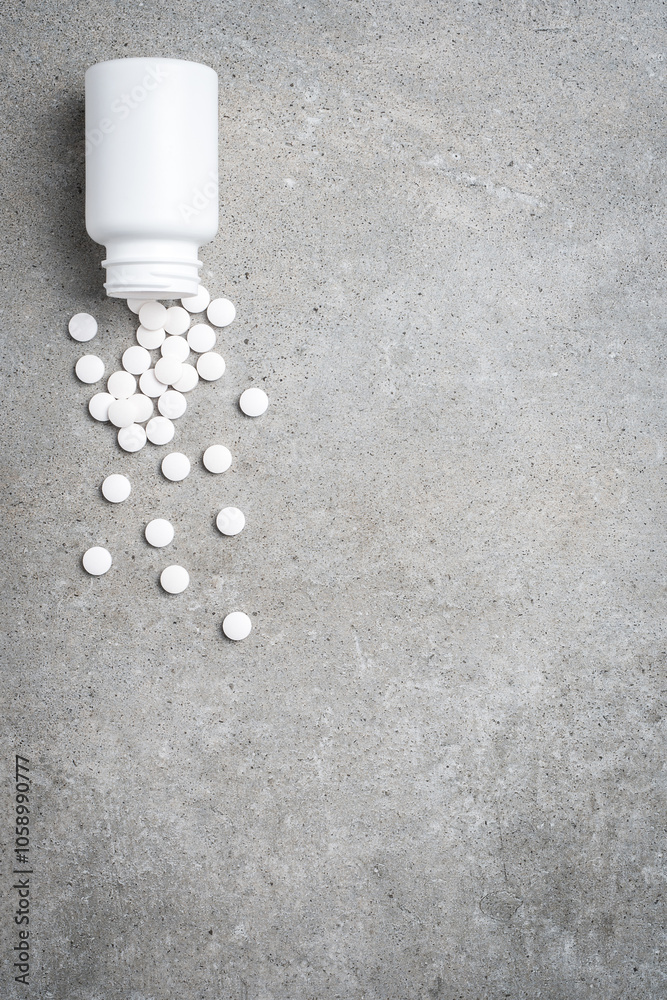 Pill bottle on gray stone background