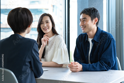 Cuadro en lienzo 説明をするスーツを着た女性と話を聞くカップル