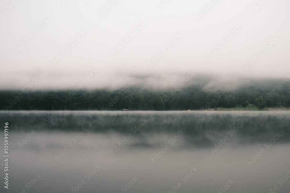 Serene lake with misty reflection Serene lake with misty reflection