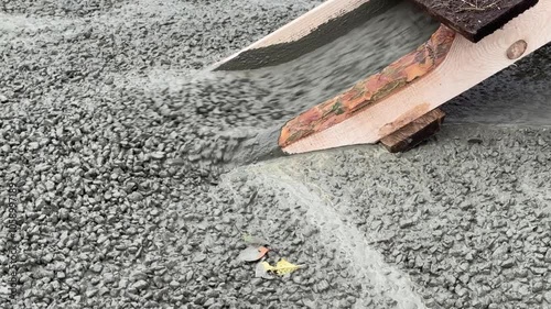 A cement mixer is pouring concrete into a wooden ramp. The ramp is being built for a construction project