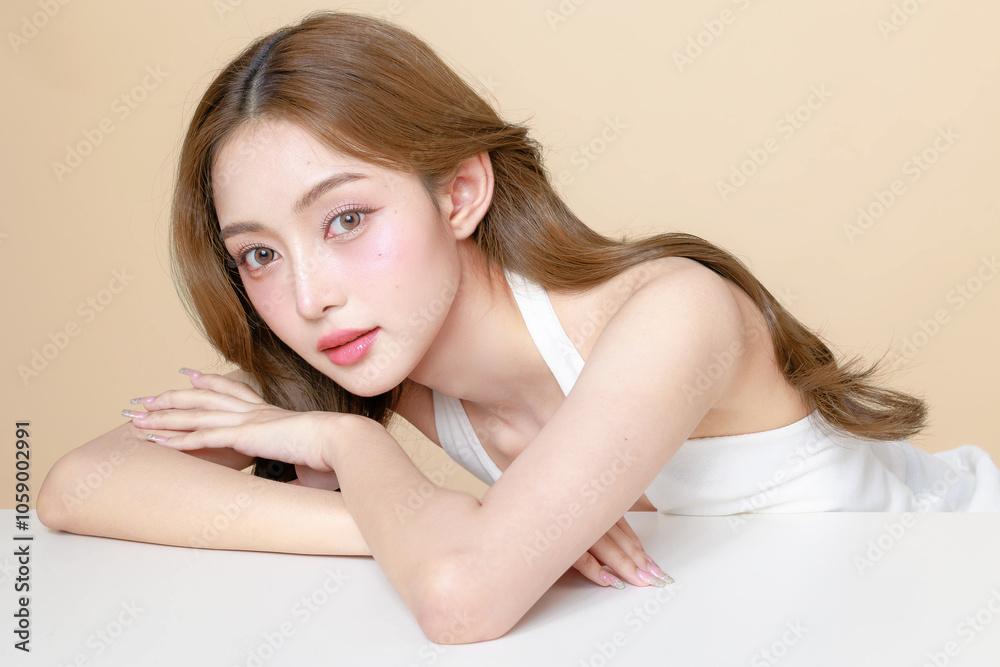 Young Asian beauty woman curly long hair with korean makeup style touch her face and perfect skin on isolated beige background. Facial treatment, Cosmetology, plastic surgery. Young Asian beauty woman curly long hair with korean makeup style touch her face and perfect skin on isolated beige background. Facial treatment, Cosmetology, plastic surgery.