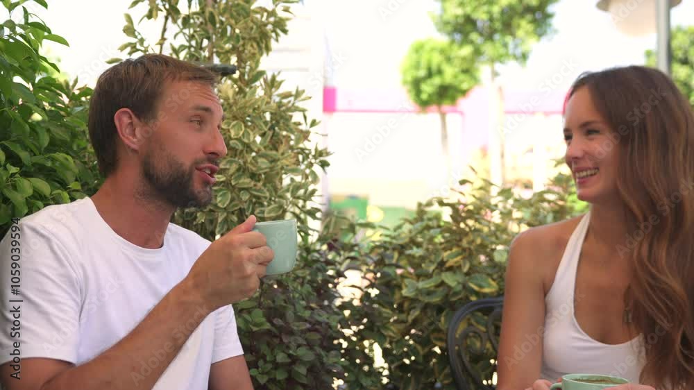 A romantic couple enjoys a close-up moment, sipping coffee and sharing cheesecake in a lush green setting. Their relaxed expressions and warm conversation.