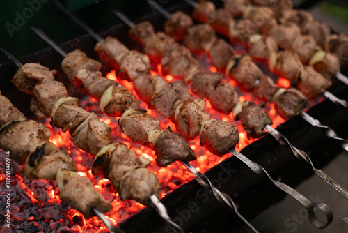 Marinated shashlik or shish kebab preparing on skewers over charcoal