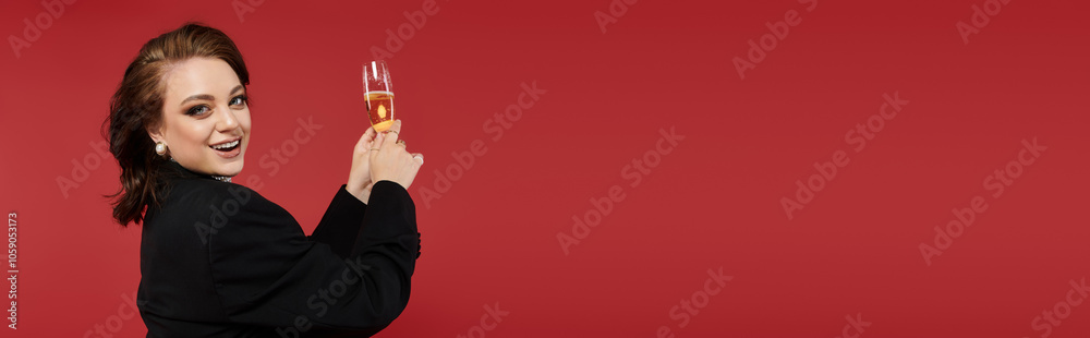A beautiful young woman raises a champagne glass, smiling elegantly in her stylish outfit. A beautiful young woman raises a champagne glass, smiling elegantly in her stylish outfit.