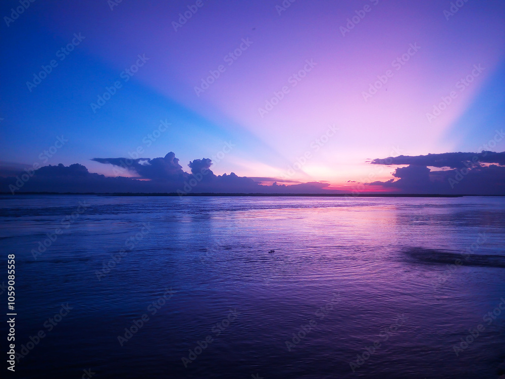a sunset over the ocean with clouds and sun rays a sunset over the ocean with clouds and sun rays