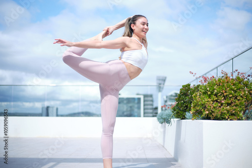 A young woman doing a yoga workout at the rooftop photo