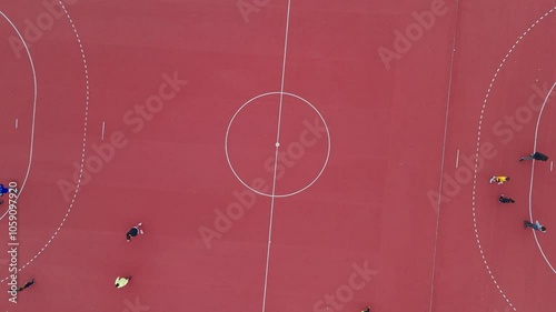 Aerial view of a vibrant synthetic football field adjacent to a green park, showcasing sports and leisure from above photo