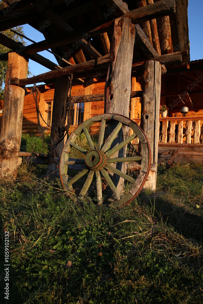 Old wooden wheel with wooden spokes, atmosphere of village, old time Old wooden wheel with wooden spokes, atmosphere of village, old time