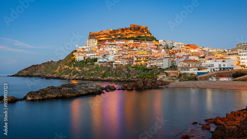 Fototapeta Naklejka Na Ścianę i Meble -  Picturesque panoramic view of the medieval town of Castelsardo at the beginning of the blue hour, Province of Sassari, Sardinia, Italy, Europe.