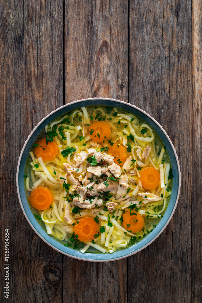 Broth - chicken soup with vegetables on wooden table
Broth - chicken soup with vegetables on wooden table