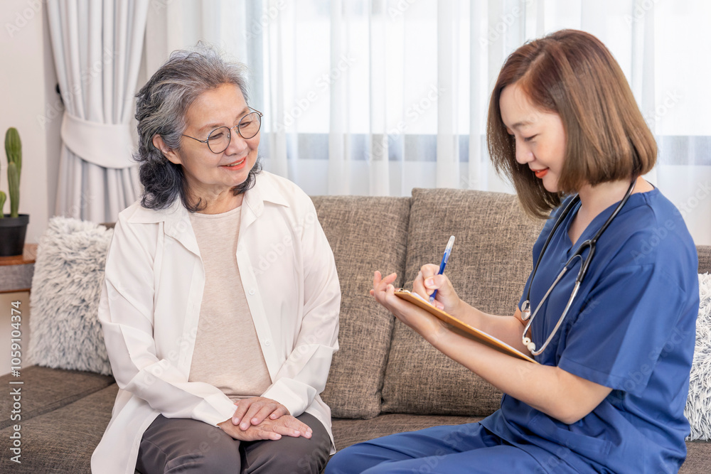 Obraz premium asian senior woman giving health interview to home visiting nurse that holding paper clipboard taking patient data notes,concept of elderly health,homecare,home health nursing