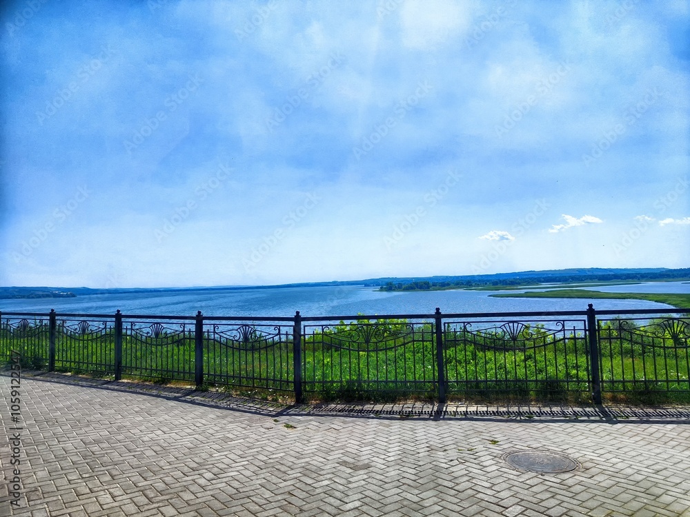 Scenic view of a tranquil lake with green hills and blue sky on a sunny day Scenic view of a tranquil lake with green hills and blue sky on a sunny day
