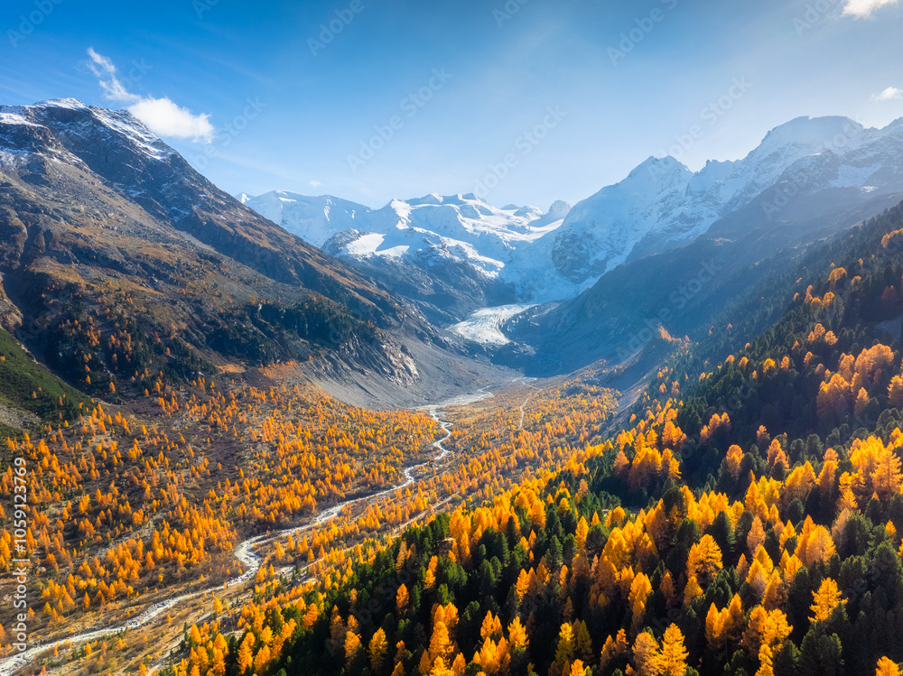 Drone view of a mountain valley. River in the middle of the forest. Autumn landscape from the air. Sun rays in the mountains. Photo for background, wallpaper, postcards.