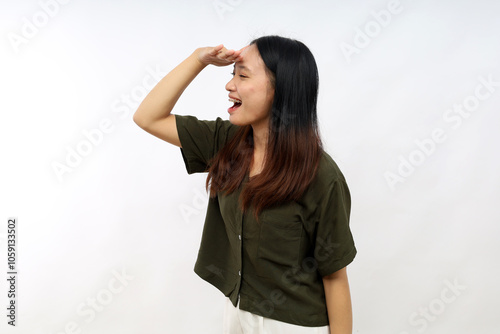 Young woman wearing casual shirt very happy and smiling looking far away with hand over head. searching concept.