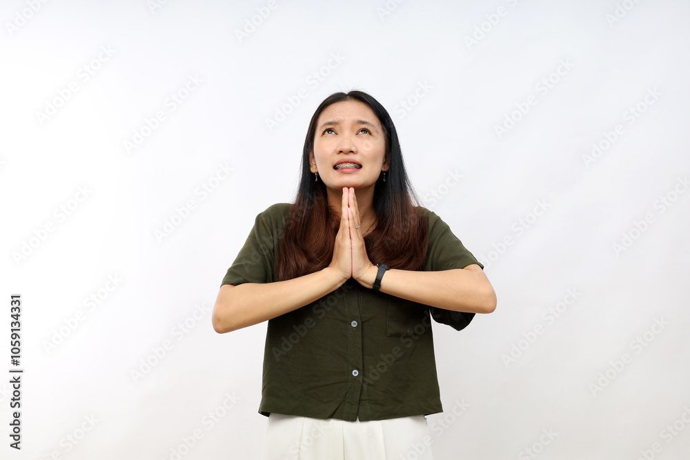 Young asian woman wearing casual shirt begging and praying with hands together with hope expression on face very emotional and worried. begging. Young asian woman wearing casual shirt begging and praying with hands together with hope expression on face very emotional and worried. begging.