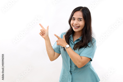 Beautiful young Asian woman pointing up to copy space and looking at camera with smile face and happy Pretty girl act like a satisfied product, use for advertising with isolated on white background