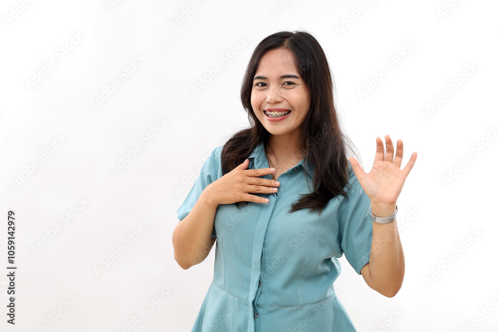 Happy dark haired pretty Asian woman with positive expression laughs joyfully keeps hand raised smiles broadly wears casual shirt earrings hears something funny isolated over white background.