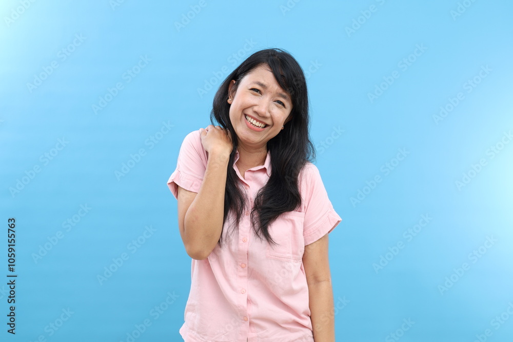 Fototapeta premium Charming Asian woman has cheerful expression standing against blue background