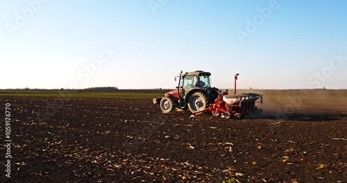 An aerial shot of a farmer in tractor seeding soybean