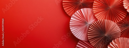 Colorful decorative paper fans arranged on a vibrant red background for a fes...
