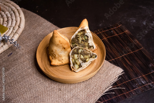 Liver ingara or Kolija singara served in plate isolated on dark background side view of bangladeshi fast food photo