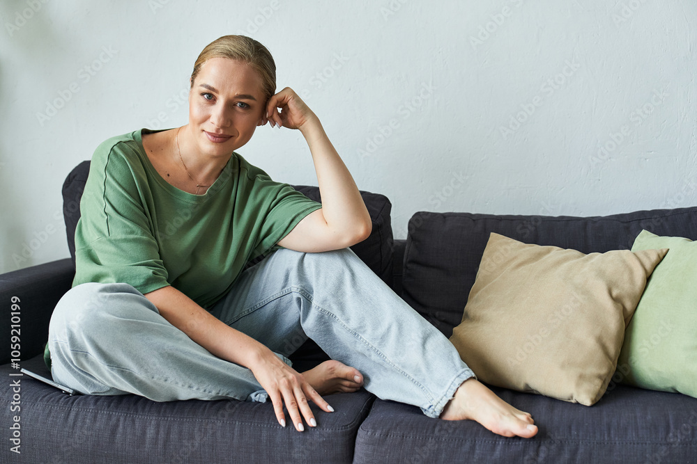 A cheerful young woman with a graceful pose enjoys a moment of tranquility on her sofa. A cheerful young woman with a graceful pose enjoys a moment of tranquility on her sofa.
