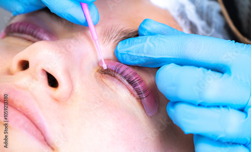 Woman during procedure of eyelashes lamination in beauty salon photo