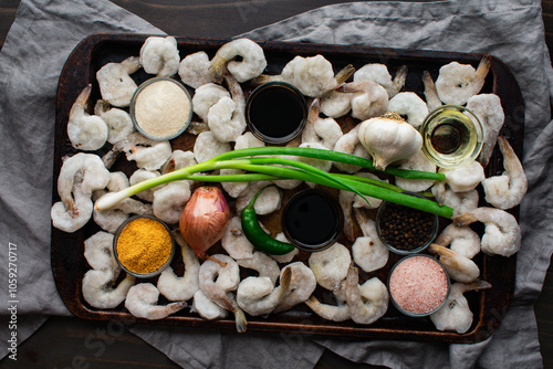 Tom Rim (Vietnamese Caramelized Shrimp) Ingredients on a Sheet Pan: Frozen shirmp with fish sauce, scallion, and more on a rustic baking sheet photo