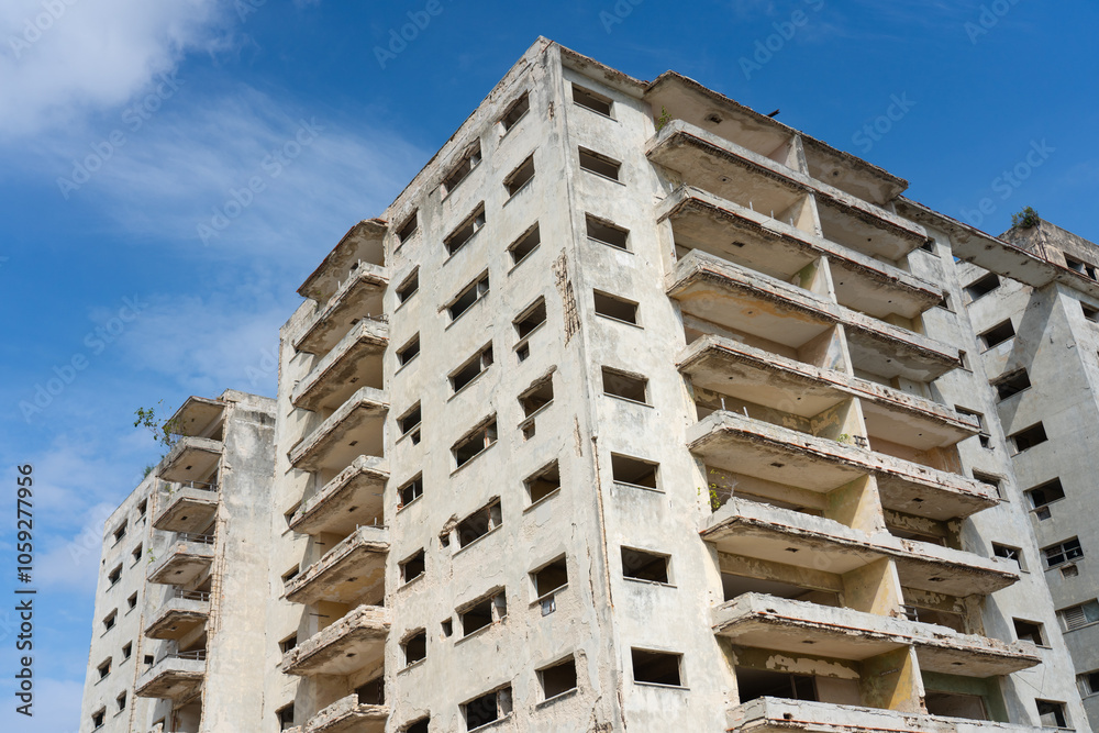 Facade of an abandoned apartment building in poor condition on a sunny day in Havana, Cuba. Facade of an abandoned apartment building in poor condition on a sunny day in Havana, Cuba.