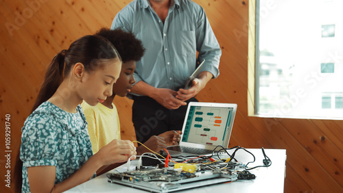 Wallpaper Mural Teacher standing while explain coding and robotic construction. Diverse teenager fixing mother board and using electronic tool while looking at laptop display programing code screen. Edification. Torontodigital.ca