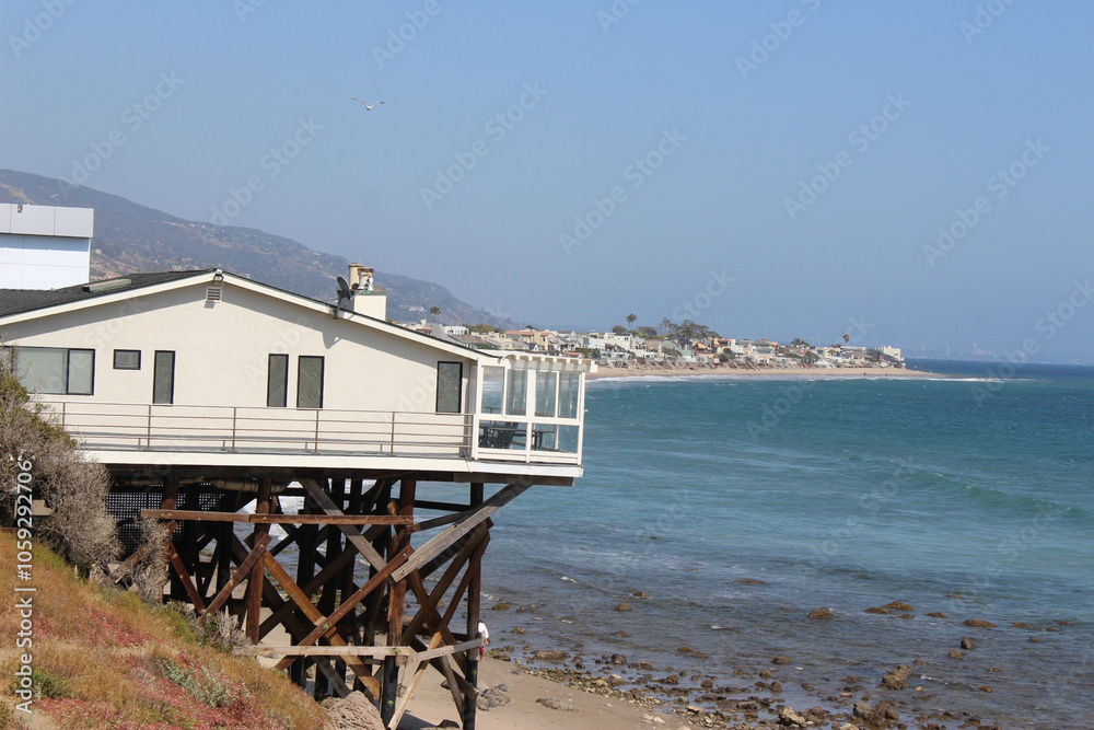 Fototapeta premium Charming Coastal Beach House with Ocean Views from Cliff