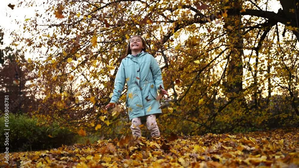 Girl throwing a pile of autumn leaves from the ground upward in slow motion. Girl throwing a pile of autumn leaves from the ground upward in slow motion.