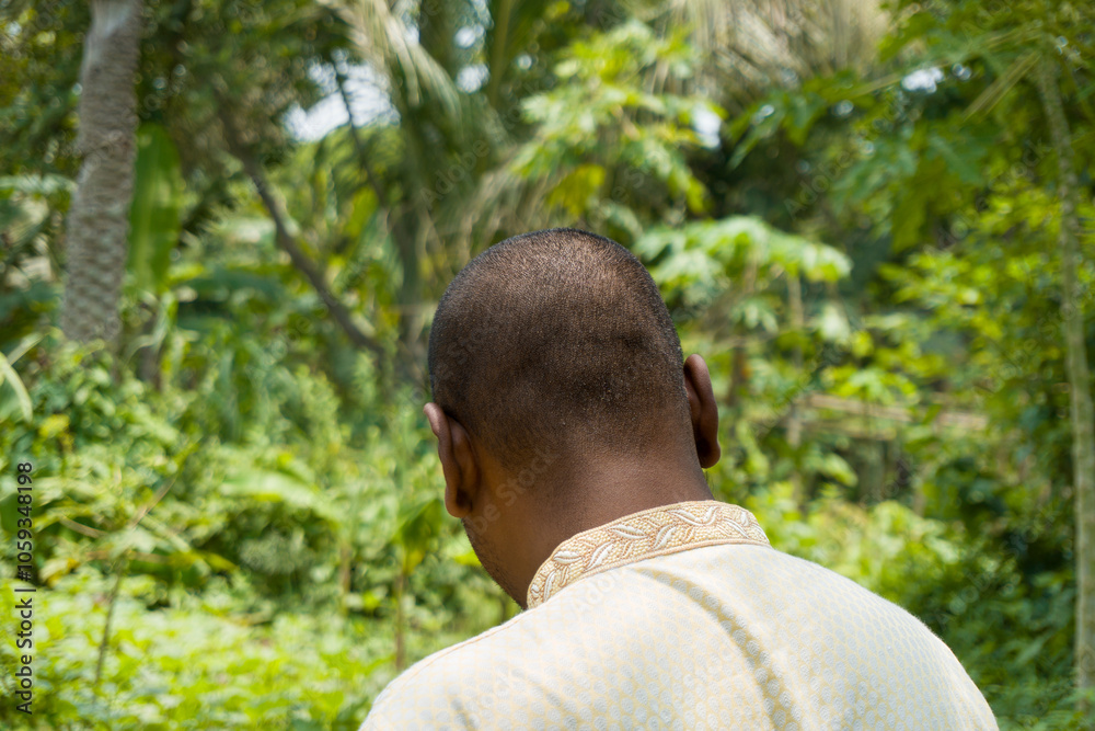 Black man with little hair standing in the green nature, Black man with short hair wearing traditional clothes Black man with little hair standing in the green nature, Black man with short hair wearing traditional clothes