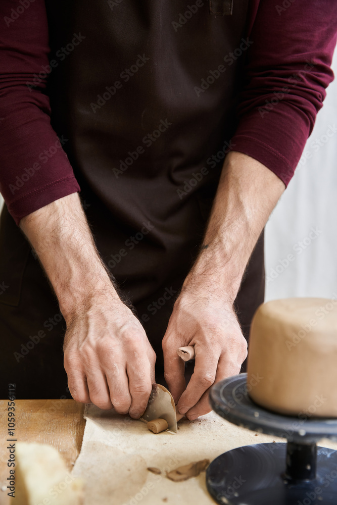Dedicated male in apron making some pottery in studio. Dedicated male in apron making some pottery in studio.