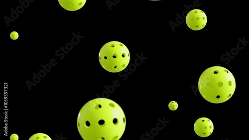 Loopable footage of falling pickle balls. Slow-motion. Black background. 4K HD