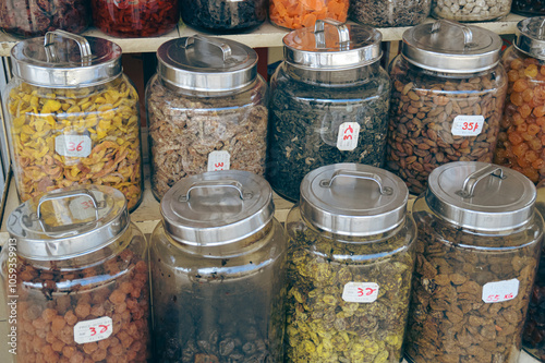 Fototapeta Naklejka Na Ścianę i Meble -  Glass jars filled with various dried candied fruits arranged on market shelves in Penang, Malaysia